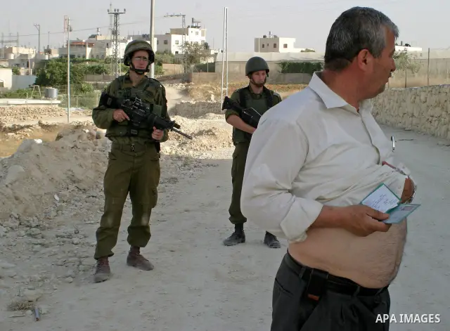 Israeli soldiers search palestinians during a military operation in the West Bank city Hebron on July1, 2009. Photo by Najeh Hashlamoun