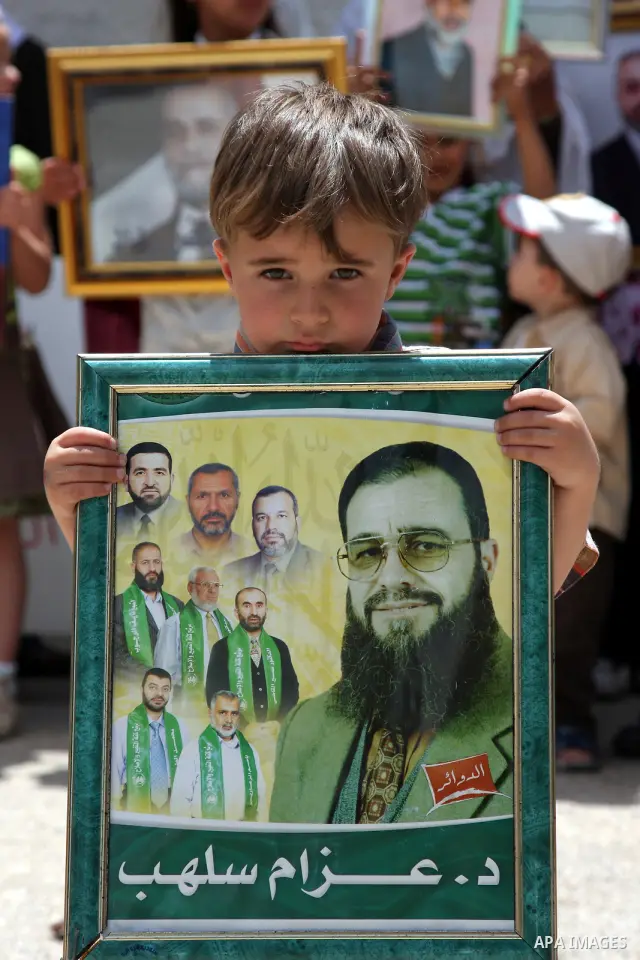 Relatives of Palestinian Hamas lawmakers, who are jailed in Israel, hold their pictures, during a protest calling for their release outside the Palestinian Legislative Council headquarters in the West Bank city of Ramall...