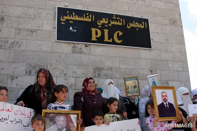 Relatives of Palestinian Hamas lawmakers, who are jailed in Israel, hold their pictures, during a protest calling for their release outside the Palestinian Legislative Council headquarters in the West Bank city of Ramall...