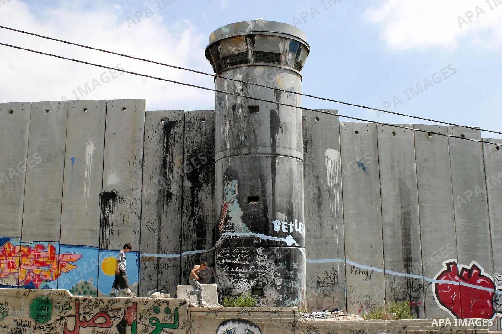 Palestinian boys walk beside the controversial Israeli barrier in Aida refugees camp in the West Bank town of Bethlehem on July 6 2009. Photo by Najeh Hashlamoun