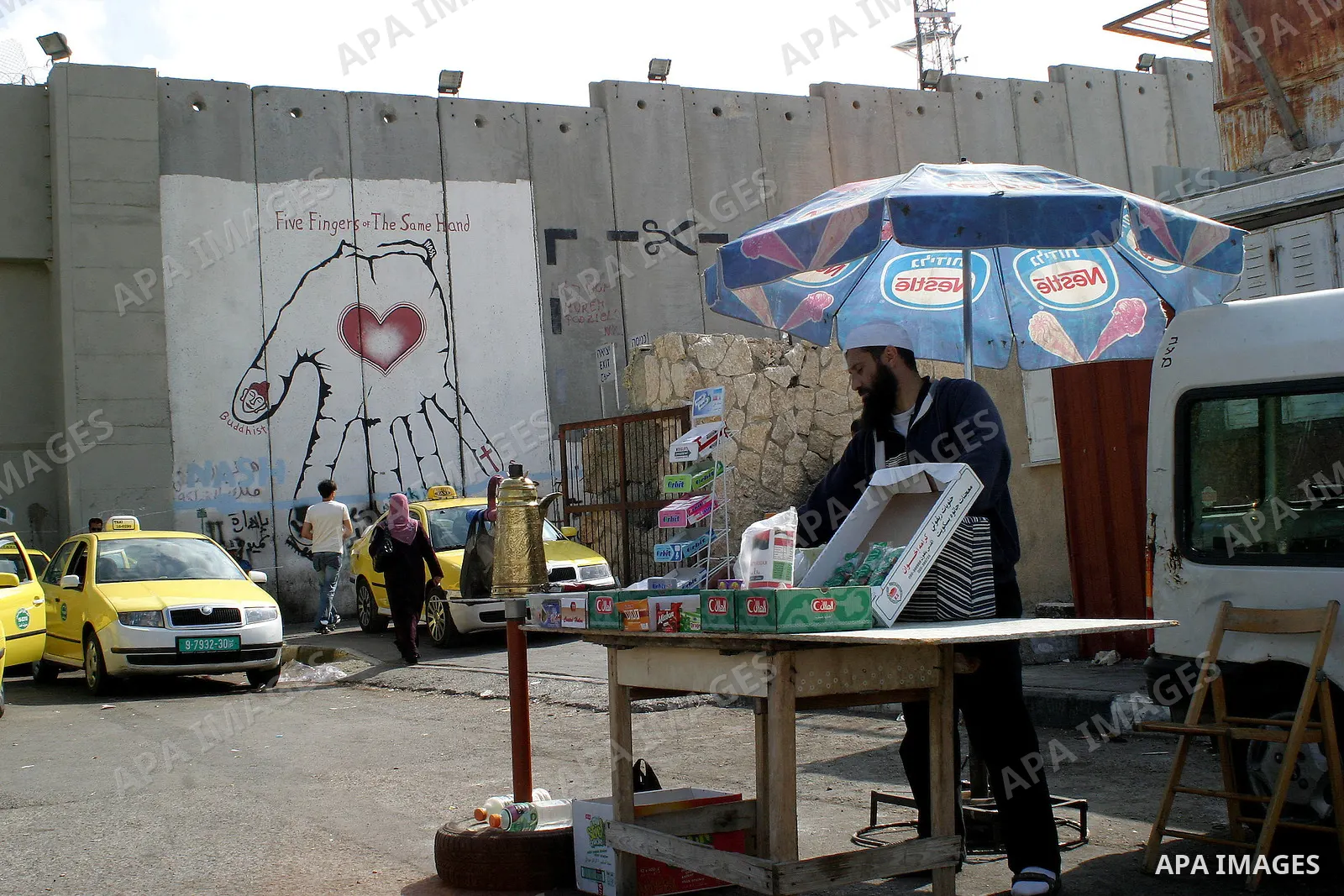 A Palestinian saler is standing near the controversial Israeli barrier near a checkpoint in the West Bank town of Bethlehem on July 6 2009. Photo by Najeh Hashlamoun