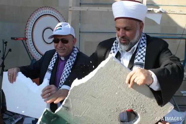 Palestinian Sheikh Tayssir Tamimi and Lutheran priest Munib Yonan destroy a symbolic section of Israels controversial separation barrier in the West Bank town of Beit Jala near Bethlehem during a rally against it on July...