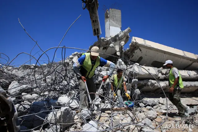Palestinian workers of the United Nations Relief and Works Agency (UNRWA) clear the rubble of houses that were destroyed during Israel's war on Gaza in Izbet Abed Rabbo in Jabalia refugee camp, northern Gaza Strip, on Ju...