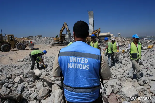 Palestinian workers of the United Nations Relief and Works Agency (UNRWA) clear the rubble of houses that were destroyed during Israel's war on Gaza in Izbet Abed Rabbo in Jabalia refugee camp, northern Gaza Strip, on Ju...