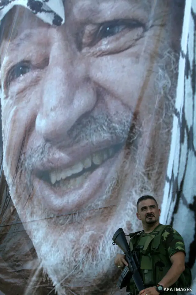 Palestinian security officer stand up near poster leader Yasser Arafat during rally for fateh movement in the west bank of Qalqilya on July 11 ,2009. Photo by Nedal Shtieh