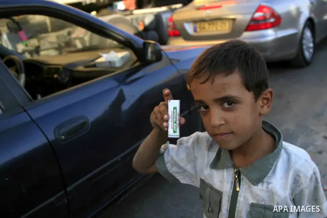 Palestinian child sells chewing gum to passengers at the Qalandiya checkpoint outside the West Bank city of Ramallah on July 19, 2009. Photo by Issam Rimawi
