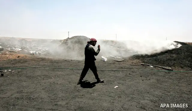 A Palestinian workers collect a coal at a work field in Gaza city on July 25, 2009. Palestinians make coal by burning a firewood to change it to coal due to Israel's closure of border crossings with the Gaza Strip and pr...