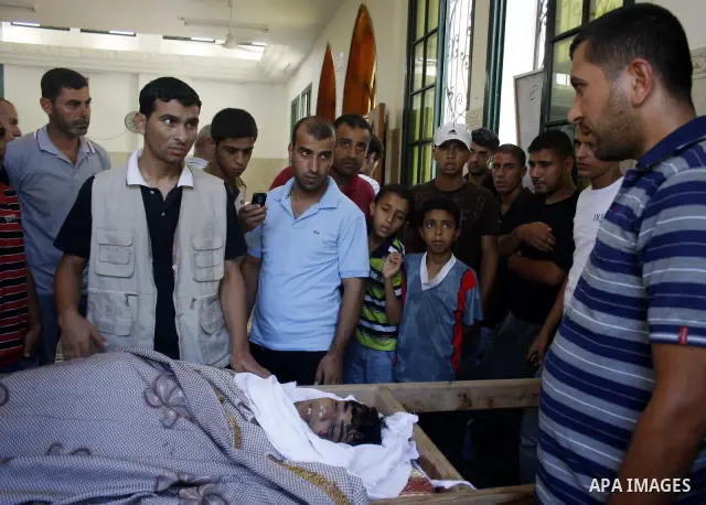 Palestinians gather around the body of the Ayman Abu Samak, who was killed in a tunnel collapse between the border of Rafah and Egypt, during his funeral at a mosque in Deir El-Balah town central Gaza Strip on July 28, 2...