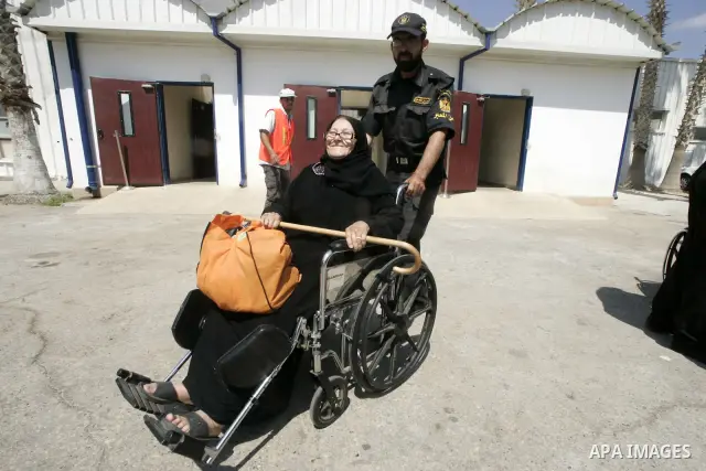 A member of Hamas policeman helps woman sick come from Egypt to the Rafah border crossing, southern Gaza Strip on Aug 3, 2009. The Rafah crossing opened on Monday for three days for Palestinians with humanitarian cases....