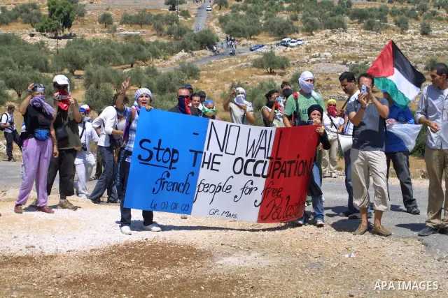 Palestinians, Israelis and foreign demonstrators hild banner wtote No Wall during a demonstration against Israel's separation barrier in the West Bank village of Bilin, near Ramallah on August 7,2009. Photo by Nedal Shti...