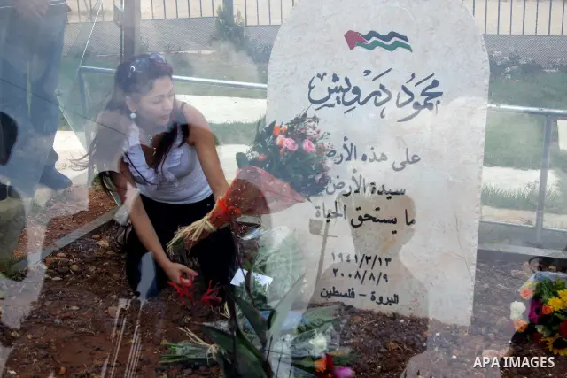 A Palestinians mark the first anniversary of the death of the Palestinian poet Mahmoud Darweish at his grave in The cultural Palace in the West Bank City of Ramallah on August 9, 2009. Photo by Issam Rimawi