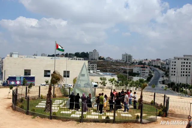 A Palestinians mark the first anniversary of the death of the Palestinian poet Mahmoud Darweish at his grave in The cultural Palace in the West Bank City of Ramallah on August 9, 2009. Photo by Issam Rimawi