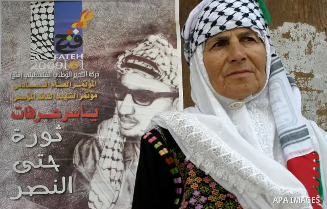 A member of Fatah Khadija Abu Arkoup stand beside of the poster of Yasser Arafat outside the Fatah congress in the West Bank town of Bethlehem August 9, 2009. Photo by Najeh Hashlamoun