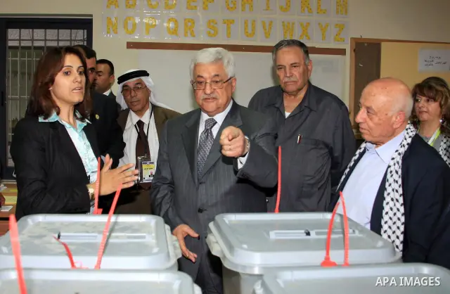 Palestinian President Mahmoud Abbas inspects the ballot booth for voting via telephone from the Gaza Strip in Bethlehem on Aug 9, 2009. photo by Omar Rashidi