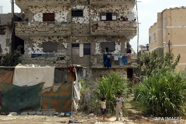 Palestinians stand on the balcony of their ruined house, hit during Israel's 22-day offensive over Gaza on August 10, 2009 in Rafah, southern Gaza Strip. sraeli warplanes bombed a smuggling tunnel along the Gaza-Egypt bo...