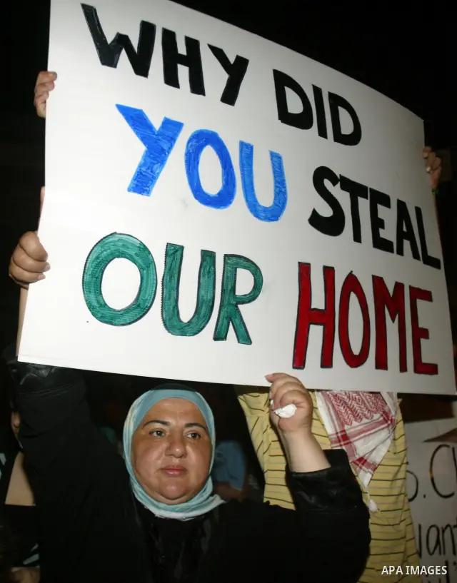 Demonstrators hold a sign as Israeli and foreign peace activists join Palestinians in a candlelight vigil in the east Jerusalem neighbourhood of Sheikh Jarrah on August 10, 2009 to protest against the eviction of two Pal...