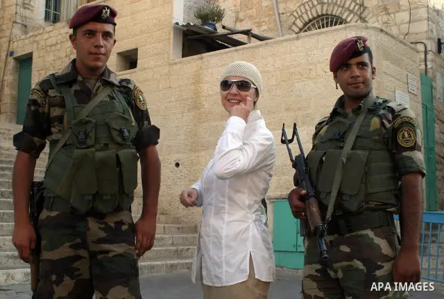 A Foreign tourist take pictures with Palestinian soldiers as they stand guard near of the Church of the Nativity, during the Fatah conference in the West Bank town of Bethlehem on August 11, 2009. Photo by Najeh Hashlamo...