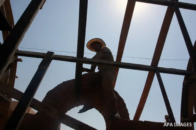 A Palestinian worker uses clay bricks to rebuild a Hamas police station in Beit Lahiya in the northern Gaza Strip August 12, 2009. The police station was destroyed during the three-week offensive Israel launched last Dec...