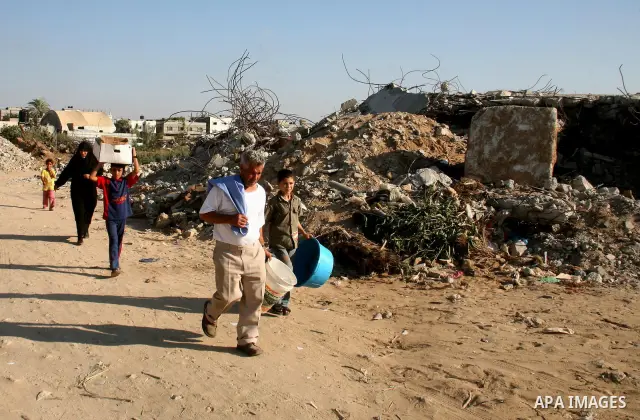 A Palestinian family walks past the rubble of a mosque that was destroyed during Israel's offensive on the Gaza Strip earlier this year, in al-Zaitoun neighbourhood of Gaza City on August 13, 2009. Israeli soldiers shot...