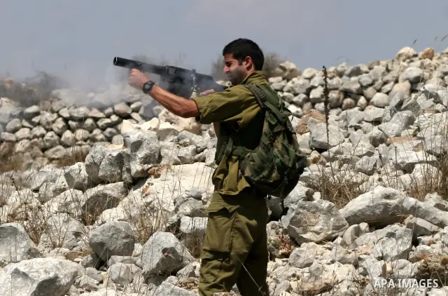 Israeli soldier shoot tear gaz at Palestinians during a protest against the confiscation of land by the Jewish settlement of Bracha in the West Bank village Burin, near Nablus on Aug 14, 2009. Photo by Nedal Shtieh