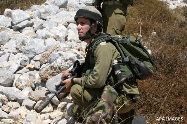 Israeli soldiers take positions during a protest against the confiscation of land by the Jewish settlement of Bracha in the West Bank village Burin, near Nablus on Aug 14, 2009. Photo by Nedal Shtieh