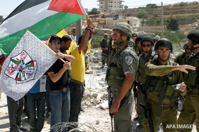 Palestinians chant slogans as Israeli soldiers stand guard during a rally against Israel's separation barrier in the West Bank village of Maasarah, near Bethlehem, Aug. 14, 2009. Photo by Najeh Hashlamoun