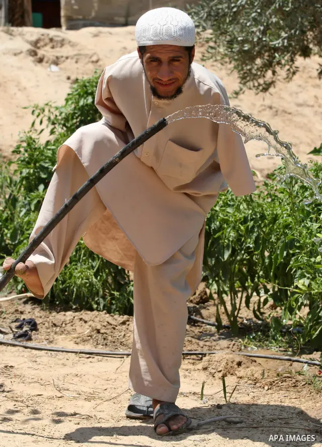 KHAN YOUNIS, Aug. 16, 2009 -- Abdurrahman, 21, is seen at his house in southern Gaza Strip town of Khan Younis. Born without arms, the university student can open his books, write, use the computer, eat and drink and eve...