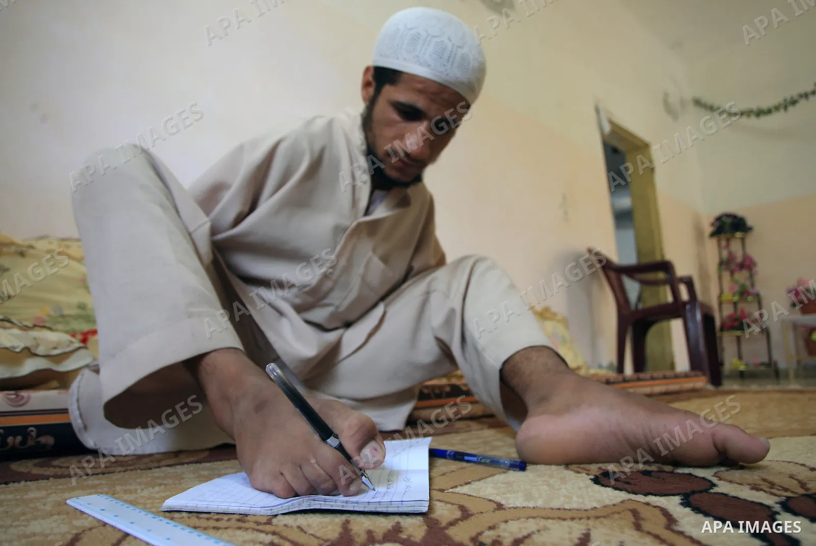 KHAN YOUNIS, Aug. 16, 2009 -- Abdurrahman, 21, is seen at his house in southern Gaza Strip town of Khan Younis. Born without arms, the university student can open his books, write, use the computer, eat and drink and eve...