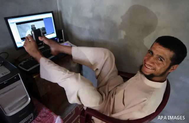 KHAN YOUNIS, Aug. 16, 2009 -- Abdurrahman, 21, is seen at his house in southern Gaza Strip town of Khan Younis. Born without arms, the university student can open his books, write, use the computer, eat and drink and eve...