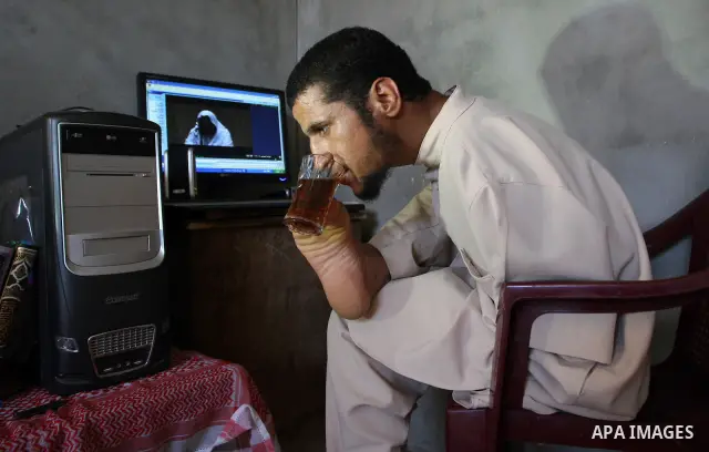 KHAN YOUNIS, Aug. 16, 2009 -- Abdurrahman, 21, is seen at his house in southern Gaza Strip town of Khan Younis. Born without arms, the university student can open his books, write, use the computer, eat and drink and eve...