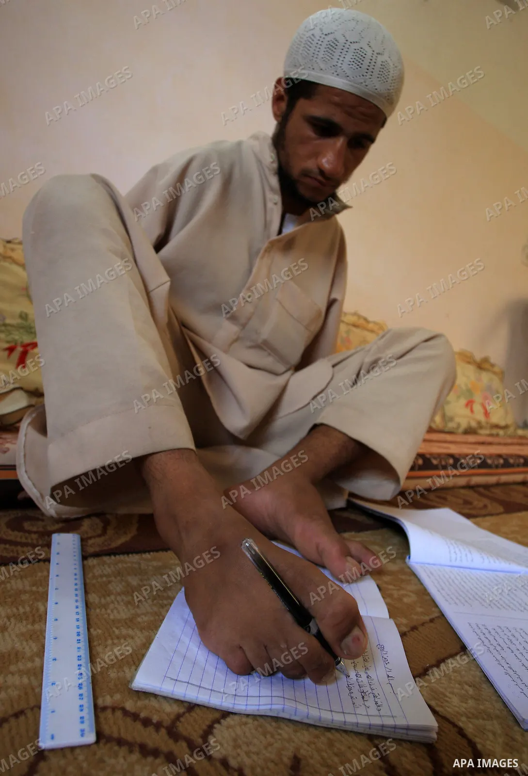 KHAN YOUNIS, Aug. 16, 2009 -- Abdurrahman, 21, is seen at his house in southern Gaza Strip town of Khan Younis. Born without arms, the university student can open his books, write, use the computer, eat and drink and eve...