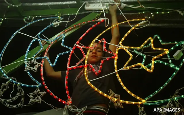 A Palestinians hangs up decorations before the Muslim holy month of Ramadan at a popular market in the old city of Jerusalem on August 19, 2009. Muslims around the world abstain from eating, drinking, and sexual relation...