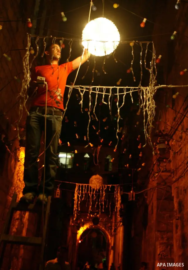 A Palestinians hangs up decorations before the Muslim holy month of Ramadan at a popular market in the old city of Jerusalem on August 19, 2009. Muslims around the world abstain from eating, drinking, and sexual relation...