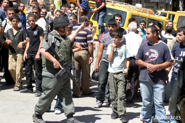 An Israeli soldiers take a positions after Palestinian man who tried to attack a soldier with a knife at an Israeli checkpoint near the Jewish settlements of Beit Hadasa and Tal Rumeida, in the West Bank city of Hebron A...