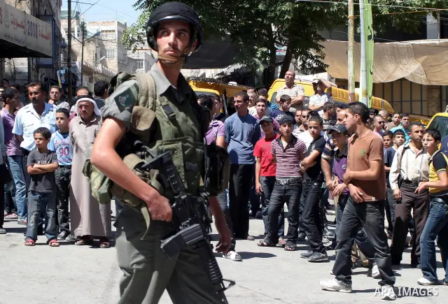 An Israeli soldiers take a positions after Palestinian man who tried to attack a soldier with a knife at an Israeli checkpoint near the Jewish settlements of Beit Hadasa and Tal Rumeida, in the West Bank city of Hebron A...