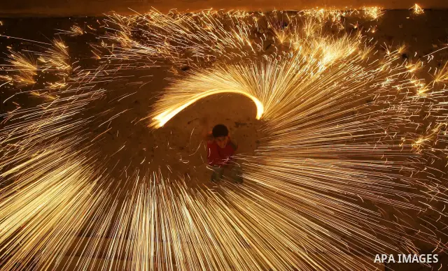 A Palestinian boy plays with fireworks in the street, in Jabaliya, northern Gaza Strip on 27 August 2009. Muslims throughout the world are celebrating the holy fasting month of Ramadan, the holiest month in Islamic calen...