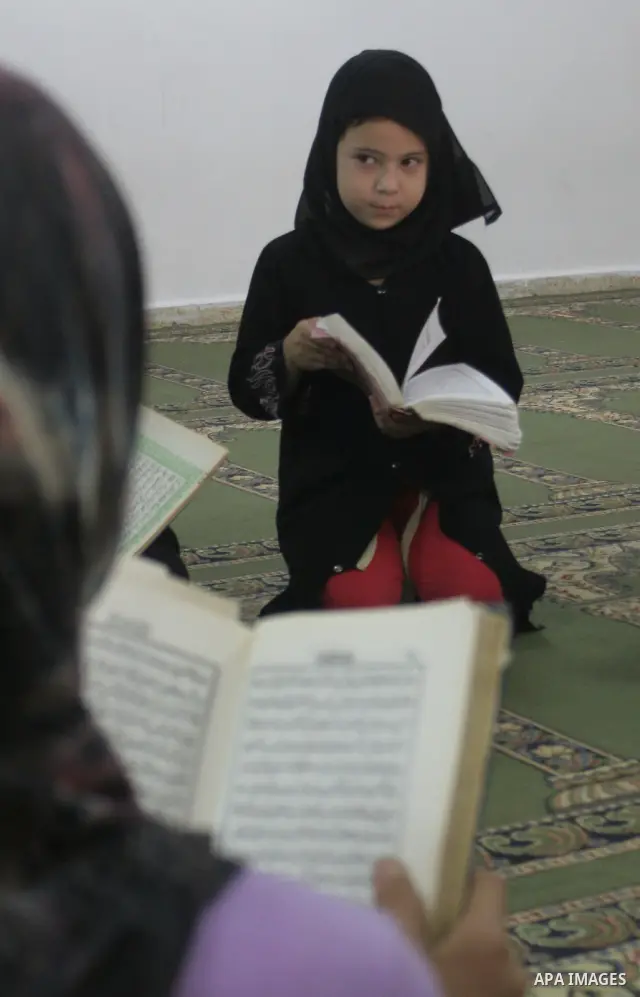 A Palestinian girls reads the Koran at a mosque in the holy month of Ramadan in Balata refugees camp in the West Bank city of Nablus on Aug 29, 2009. Photo By Nedal Shtieh