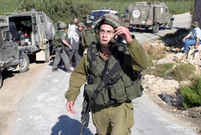 Israeli soldiers stand guard as a construction vehicle destroys a man-made reservoir on a Palestinian farm near the West Bank city of Hebron September 03, 2009. According to Israel's Civil Administration, the reservoir w...