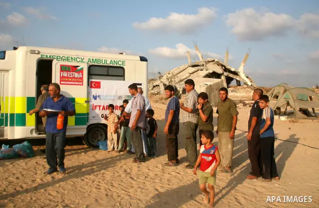 Palestinians whose houses were destroyed during Israel's offensive on the Gaza Strip, receive food donations for Ramadan's daily iftar meal at Ezbet Abd Rabbo in Jabalia Refugee camp, northern Gaza Strip, on September 3,...