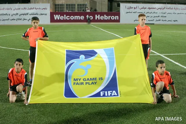 Palestinian children carrying FIFA Flag during Palestinian Olympic team and Jordanian Olympic team during a friendly game at Al-Hussein stadium during the opening ceremony of a new football field in the West Bank city of...