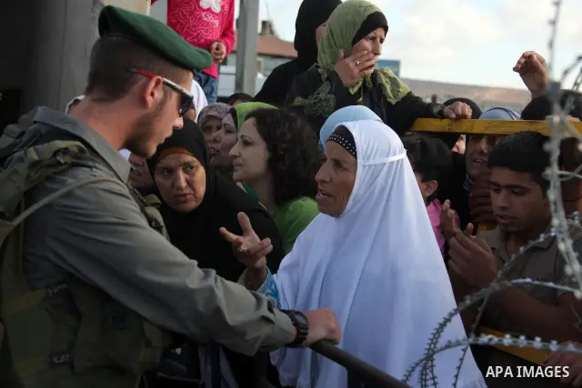 Palestinian women cross the Israeli Qalandia checkpoint, on their way to attend prayers in the Al-Aqsa Mosque compound in Jerusalem, Friday Sep 11, 2009, the third Friday of the Muslim holy month of Ramadan. Israel loose...
