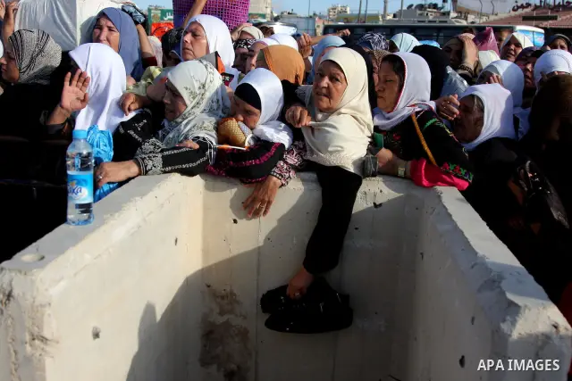 Palestinian women cross the Israeli Qalandia checkpoint, on their way to attend prayers in the Al-Aqsa Mosque compound in Jerusalem, Friday Sep 11, 2009, the third Friday of the Muslim holy month of Ramadan. Israel loose...