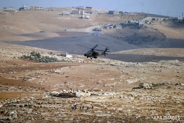 An Israeli army helicopter hovers over the site where a fighter jet crashed in the southern hills of Hebron in the West Bank on September 13, 2009. An Israeli F-16 crashed in the West Bank, killing its pilot Assaf Ramon,...