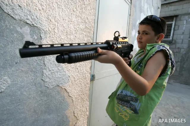 Palestinian boys play with toy guns to celebrate Eid al-Fitr during the second day of the holiday of Eid al-Fitr in Rafah refugee camp in the center of southern Gaza on the first day of the Muslim holiday Eid al-Fitr, on...