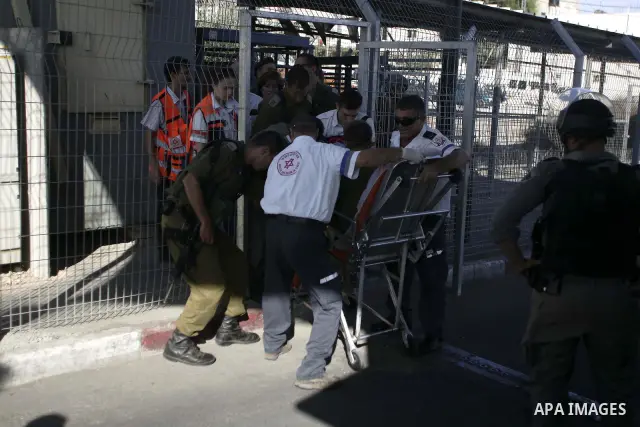A wounded Israeli soldier is treated after being stabbed by a Palestinian at a checkpoint in the Shuafat refugee camp in the West Bank near Jerusalem October 5, 2009.Clashes between Israeli police and Palestinians in the...