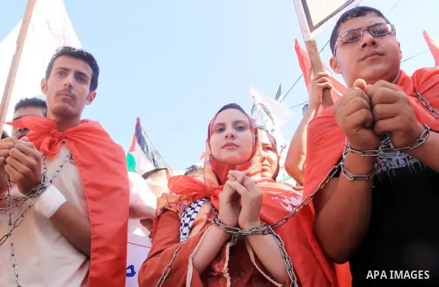 Palestinian demonstrators with chained hands take part in a protest calling for the release of Ahmed Saadat , jailed leader of the Popular Front for the Liberation of Palestine (PFLP), and other Palestinian prisoners in...