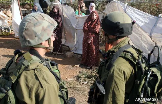 Israeli border police officers and Israeli soldiers stand guard and others destroy a pipes water on a Palestinian farms near the West Bank city of Hebron October 29, 2009. According to a spokesperson for Israel's Civil A...