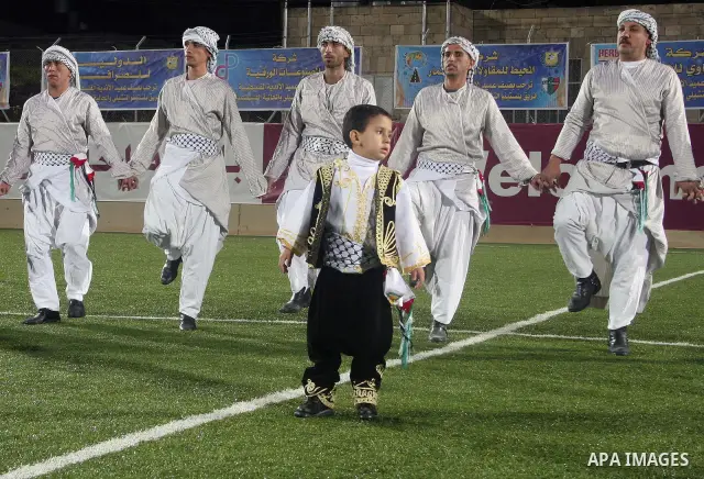 Palestinian traditional dancers are taking a part during a friendly game between Hebron Youth Club for junior against Palestino Chilean juniors at Al-Hussein stadium in the West Bank city of Hebron November 03, 2009. Pho...