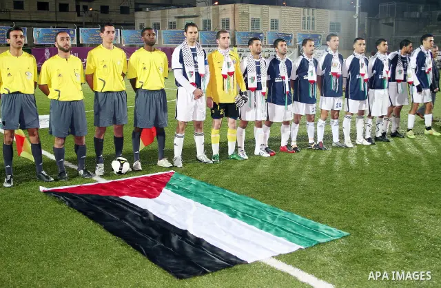 Referees and Hebron Youth Club for junior pose for a photograph during a friendly game against Palestino Chilean juniors at Al-Hussein stadium in the West Bank city of Hebron November 03, 2009. Photo by Najeh Hashlamoun