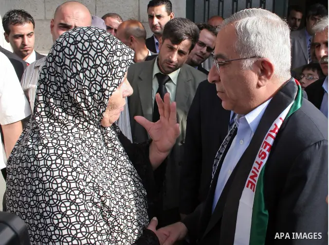 Palestinian Prime Minister Salam Fayyad, right, speaks with a resident during a visit to the West Bank city of Hebron, Thursday, Nov. 12, 2009.Photo by Najeh Hashlamoun